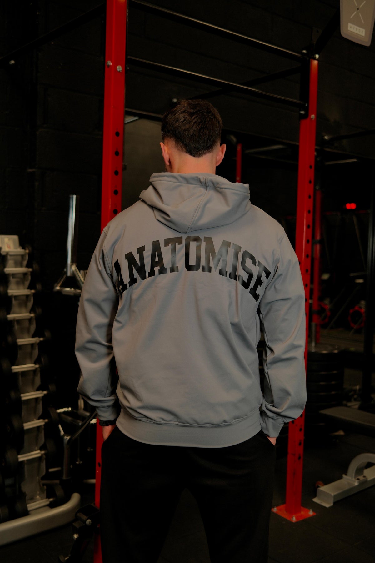 Male wearing anatomise pebble grey hoodie in the gym from back